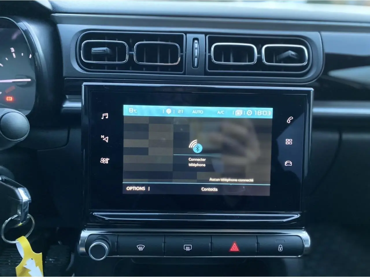 Vue rapprochée de la tablette tactile 7 pouces du tableau de bord de la Citroën C3 gris Artense 2022 avec commandes audio.