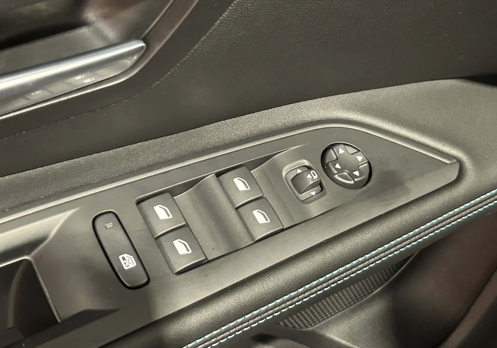 Gros plan sur les commandes des vitres et rétroviseurs côté gauche d'une Peugeot 5008 2024 finition Allure Pack gris Platinium.