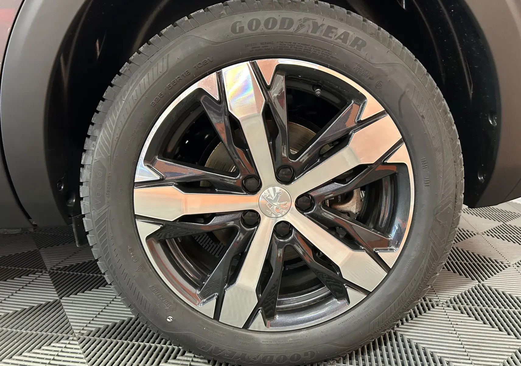 Gros plan sur la jante alliage bicolore du Peugeot 5008 Gris Platinium avec pneu Goodyear visible au sol.