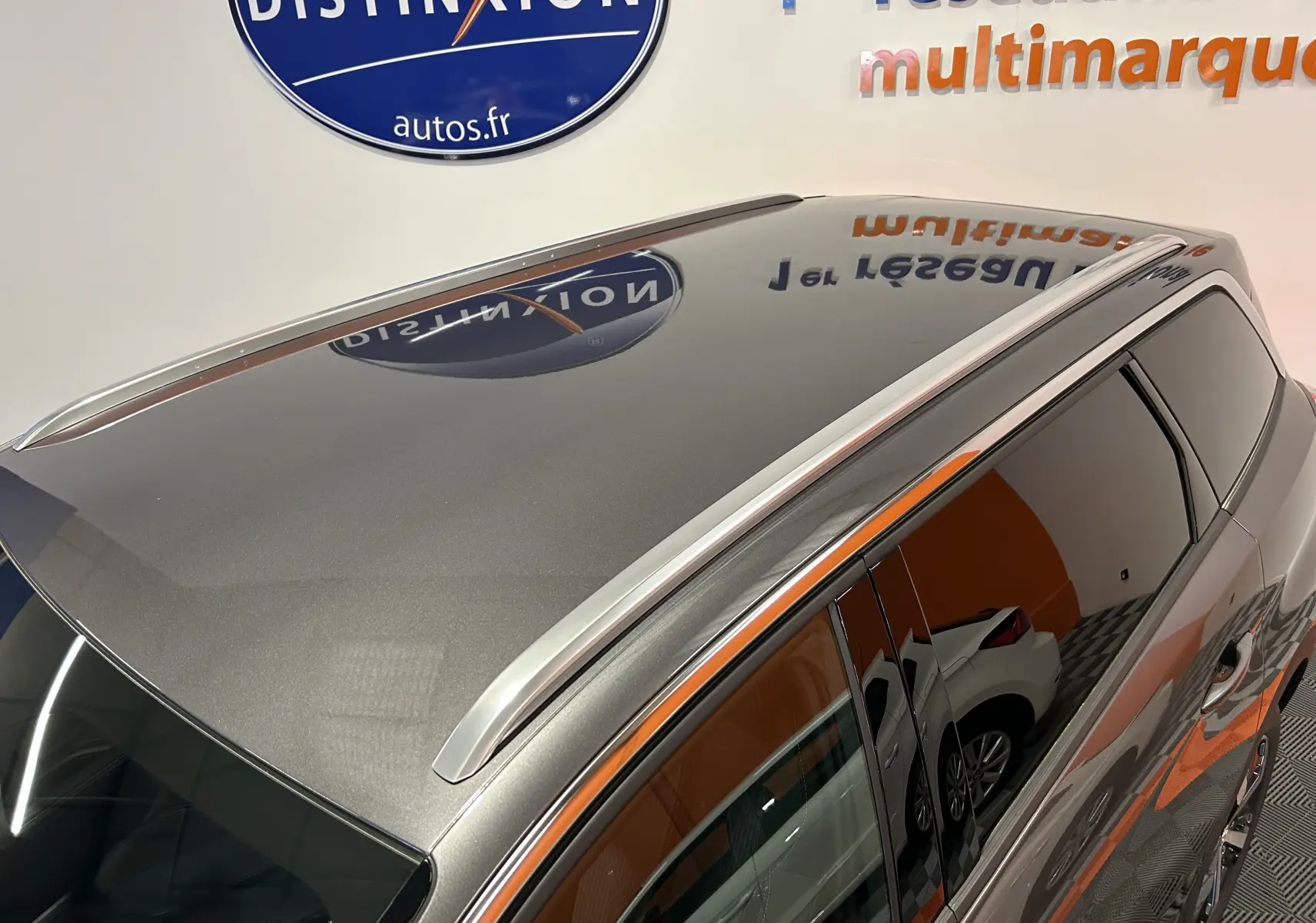 Vue en plongée du toit gris Platinium du Peugeot 5008 2024 avec barres de toit argentées et vitres teintées.