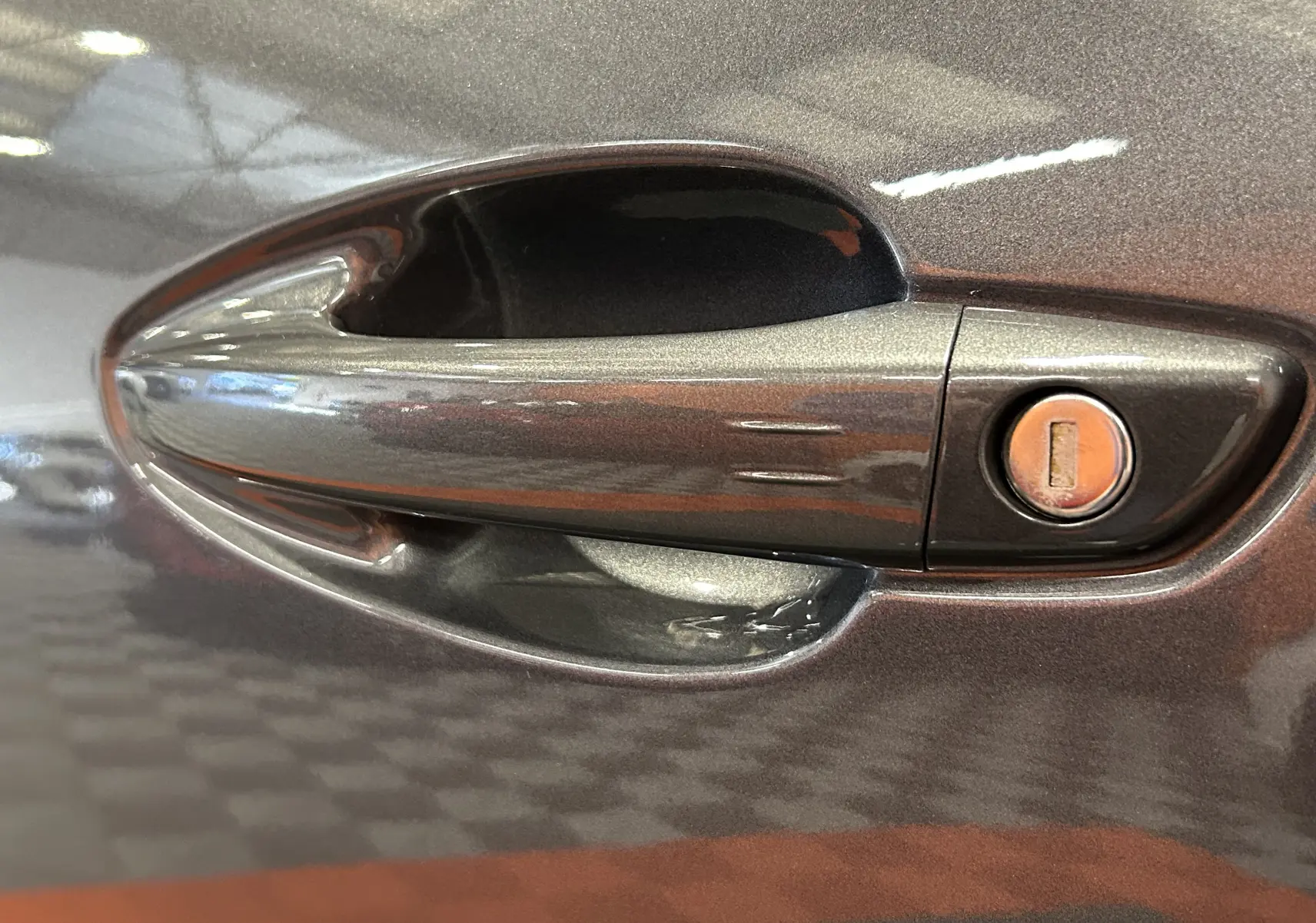 Poignée de porte côté gauche gris Platinium du Peugeot 5008 2024 BlueHDi 130 EAT8 Allure Pack avec serrure visible.