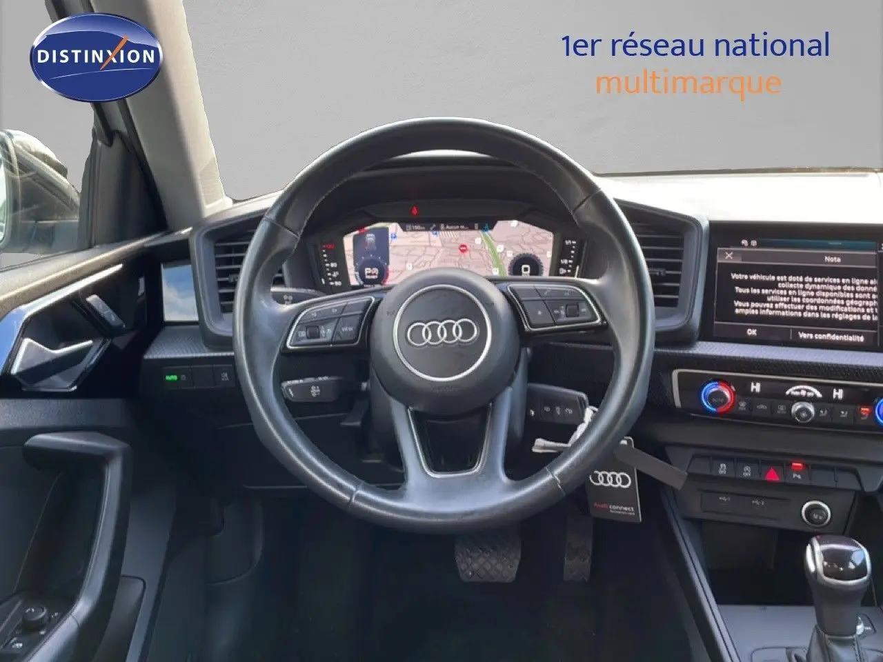 Vue intérieure du poste de conduite de l'Audi A1 Sportback 2023 avec volant multifonction et écran digital.