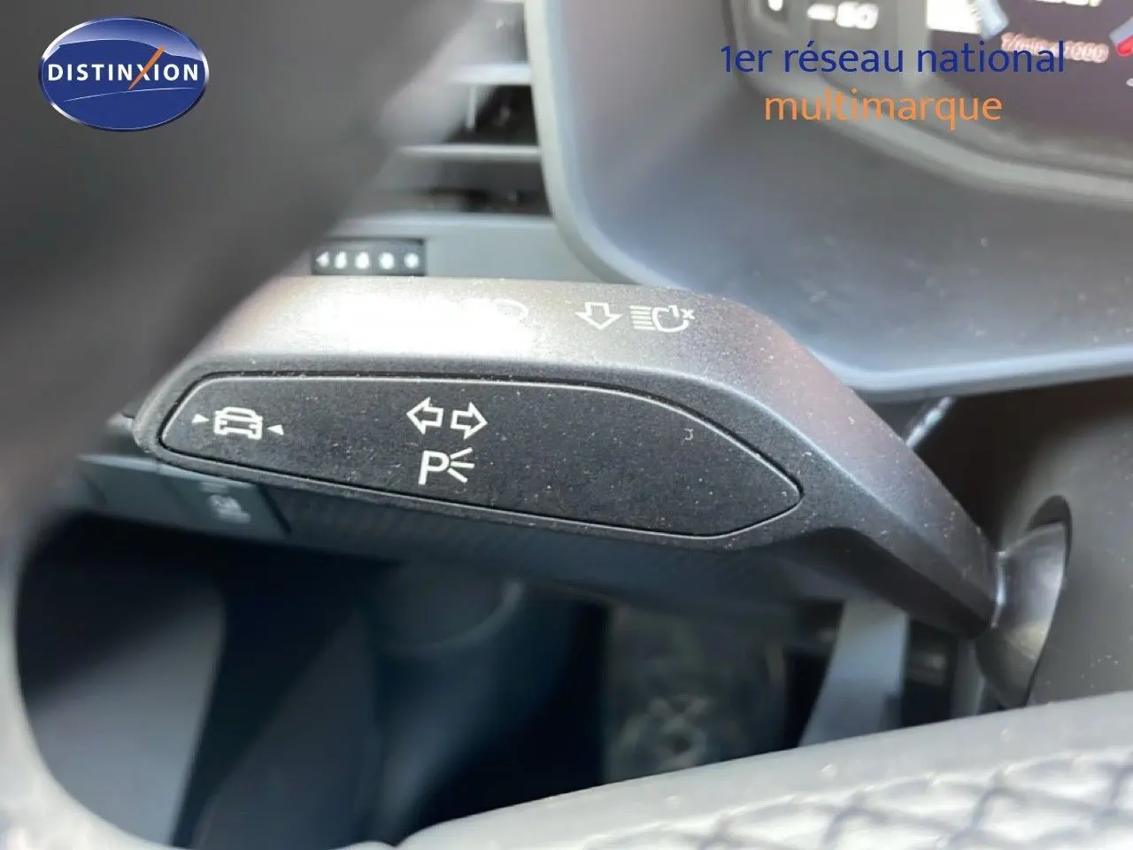 Le levier de clignotant et feux de stationnement d'une Audi A1 Sportback 2023 vue côté conducteur.