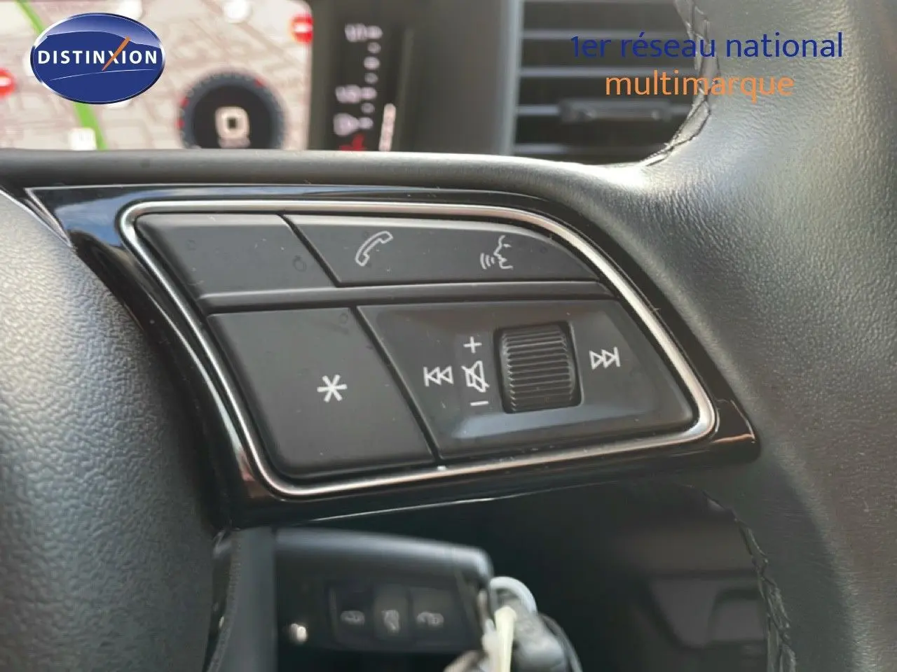 Gros plan sur les commandes audio et téléphone au volant d'un Audi A1 Sportback blanc glacier 2023.