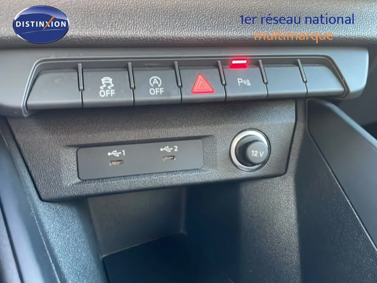 Vue rapprochée de la console centrale d'une Audi A1 Sportback blanche, montrant les commandes et ports USB.