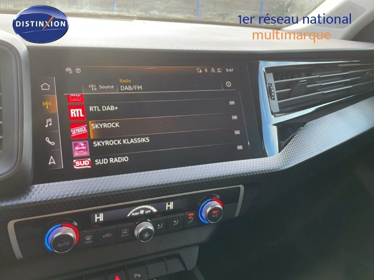 Tableau de bord de l'Audi A1 Sportback 2023 avec écran tactile radio et commandes de climatisation visibles.