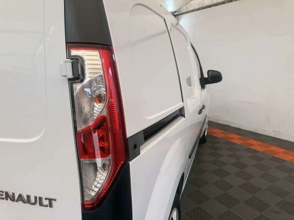 Vue 3/4 arrière droite d’un Renault Kangoo blanc avec feu arrière vertical et porte latérale coulissante.