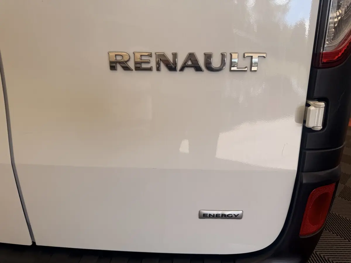 Gros plan sur la porte arrière droite blanche d’un Renault Kangoo avec logos Renault et Energy visibles.