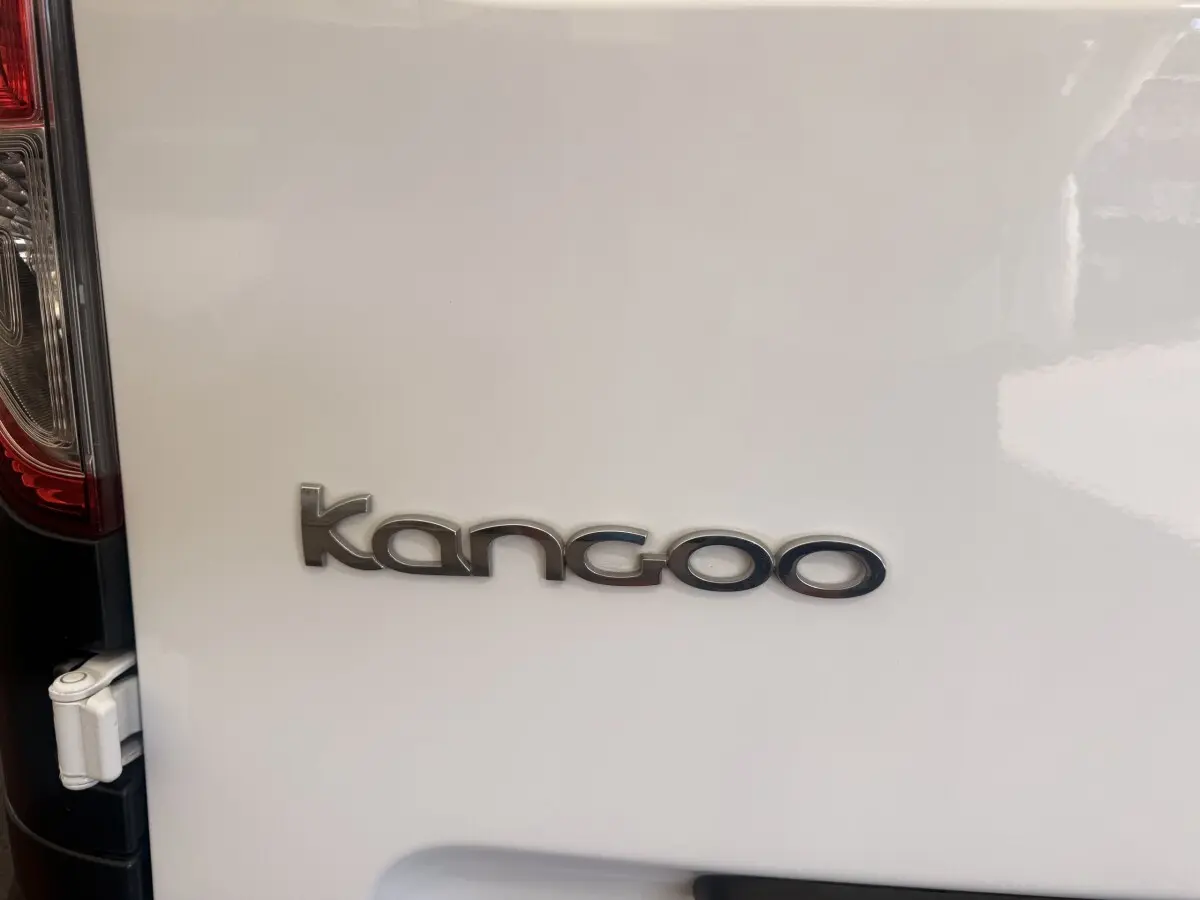 Gros plan sur l'arrière blanc d'un Renault Kangoo avec le logo "kangoo" en lettres chromées.