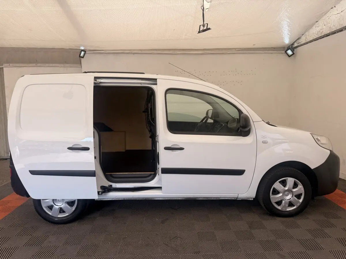 Profil droit d’un Renault Kangoo blanc 2016 avec porte latérale coulissante ouverte, intérieur de chargement visible.