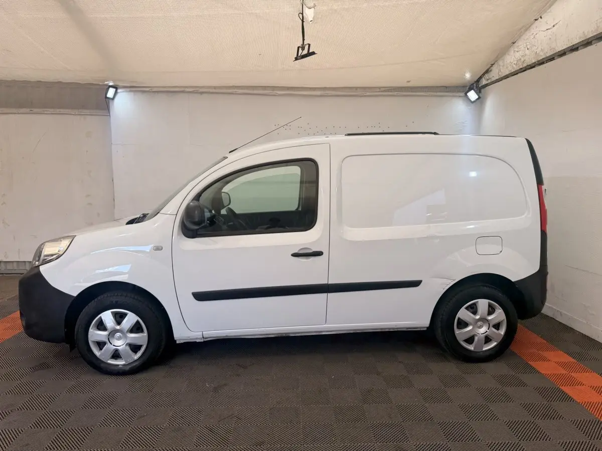 Vue latérale droite d’un Renault Kangoo blanc utilitaire avec protections noires et jantes acier en intérieur.