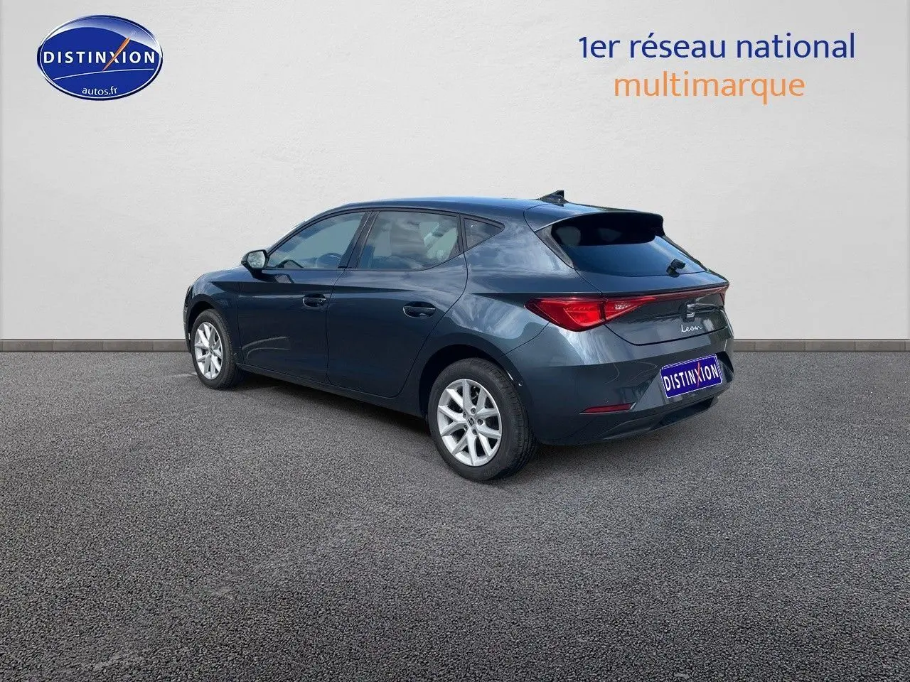 Vue 3/4 arrière droite d'une SEAT Leon IV gris magnétique métallisé avec jantes alliage et feux arrière LED.