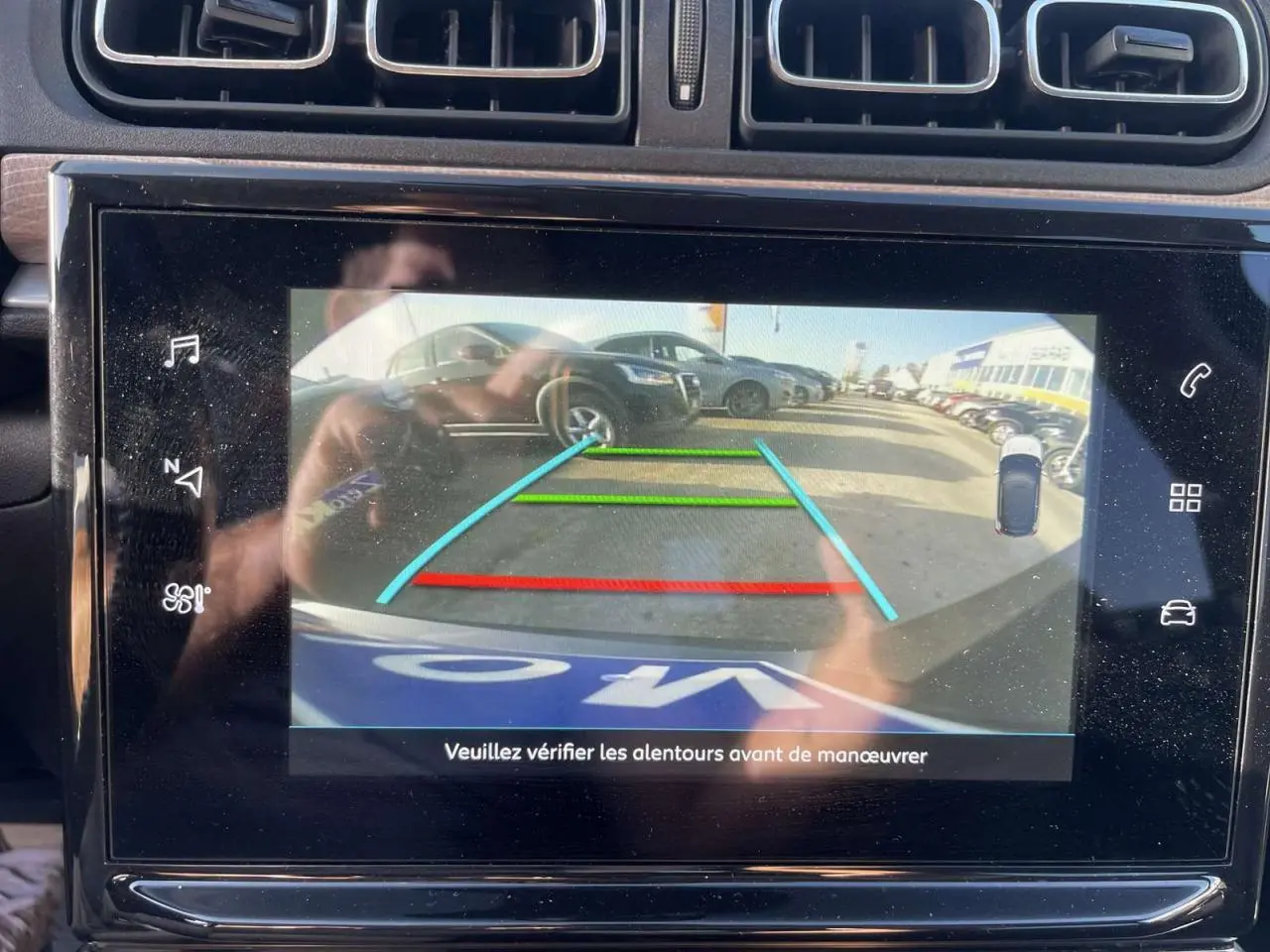 Vue de l'écran tactile de la Citroën C3 2021 montrant la caméra de recul avec les lignes d'aide au stationnement colorées.