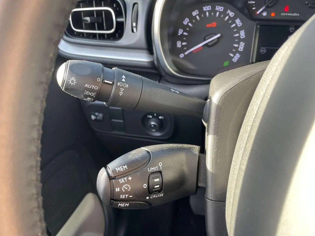 Gros plan sur les commandes au volant de la Citroën C3 1.2 83 Shine 2021, avec tableau de bord partiellement visible.