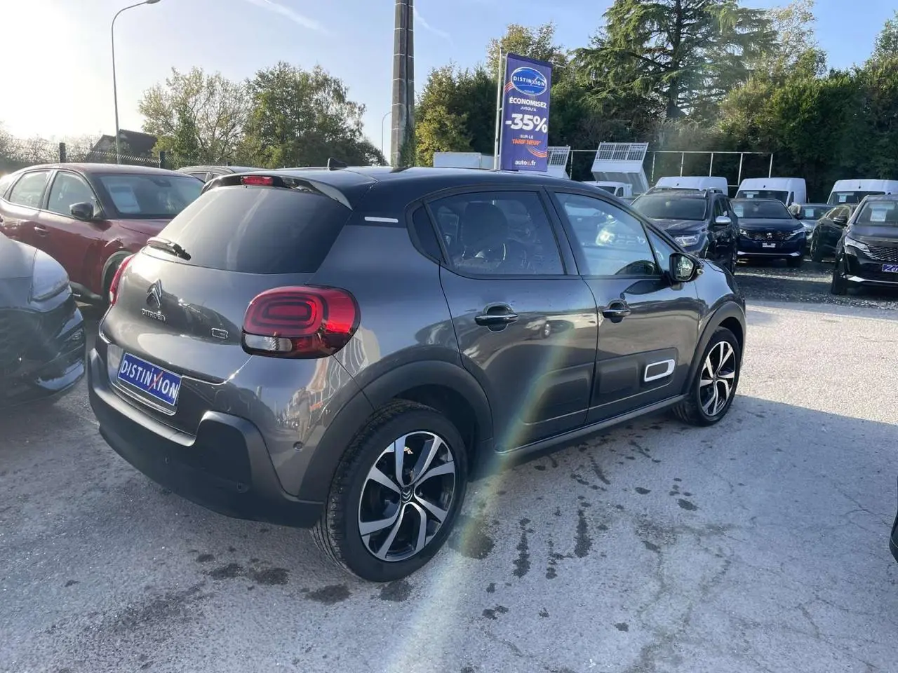Vue 3/4 arrière droite d'une Citroën C3 gris foncé avec jantes alliage diamantées et vitres surteintées.
