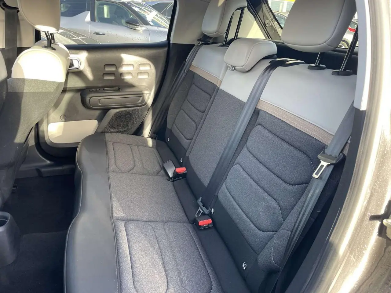 Vue intérieure de la banquette arrière gris foncé et beige de la Citroën C3 2021, côté droit ouvert.