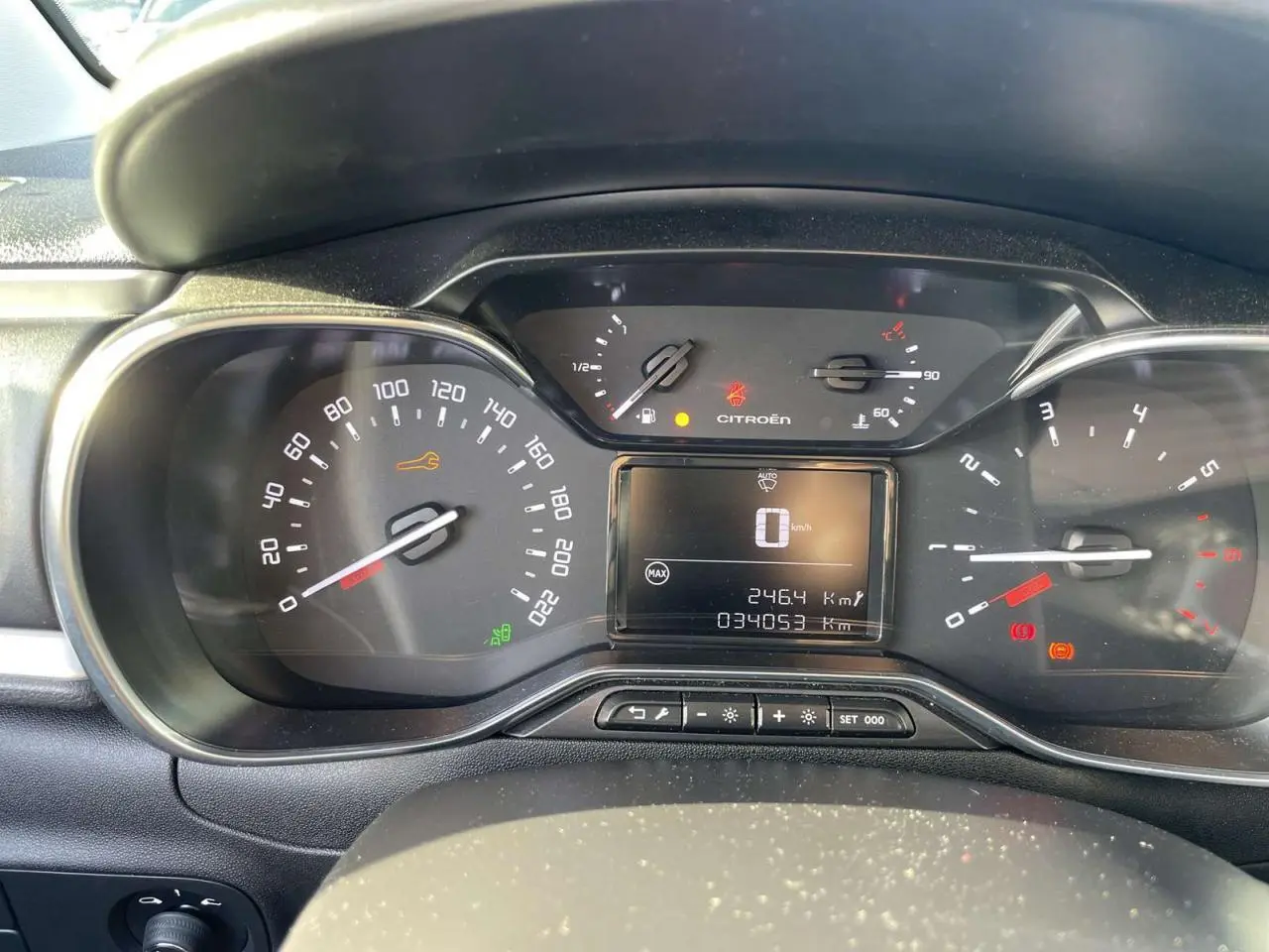 Vue rapprochée du tableau de bord de la Citroën C3 1.2 Shine 2021, affichant le compteur et les voyants allumés.