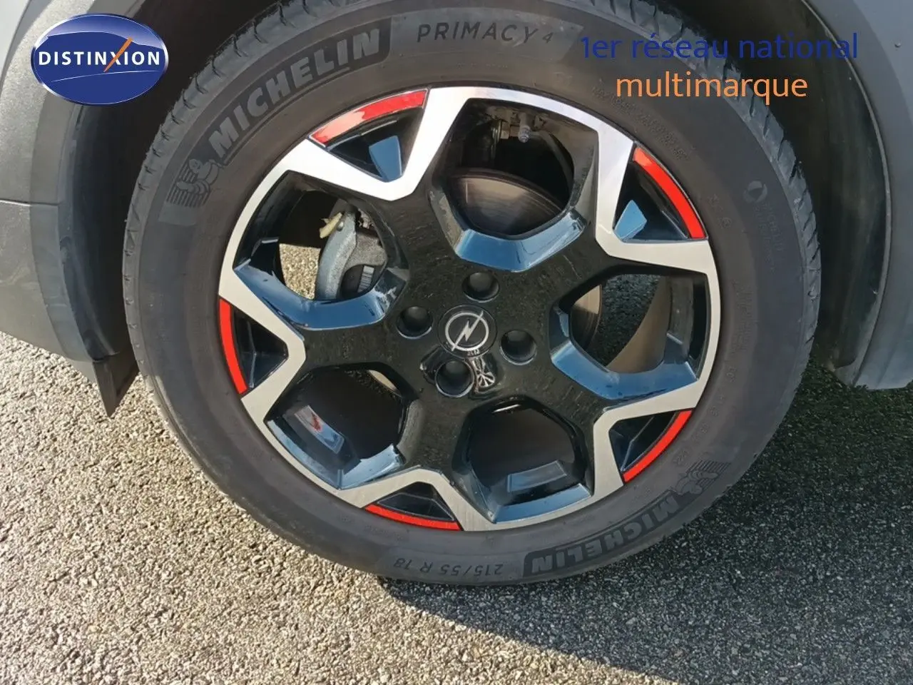 Gros plan sur la jante bi-ton noire et argent avec accents rouges d'un Opel Mokka GS Line gris quartz 2022.