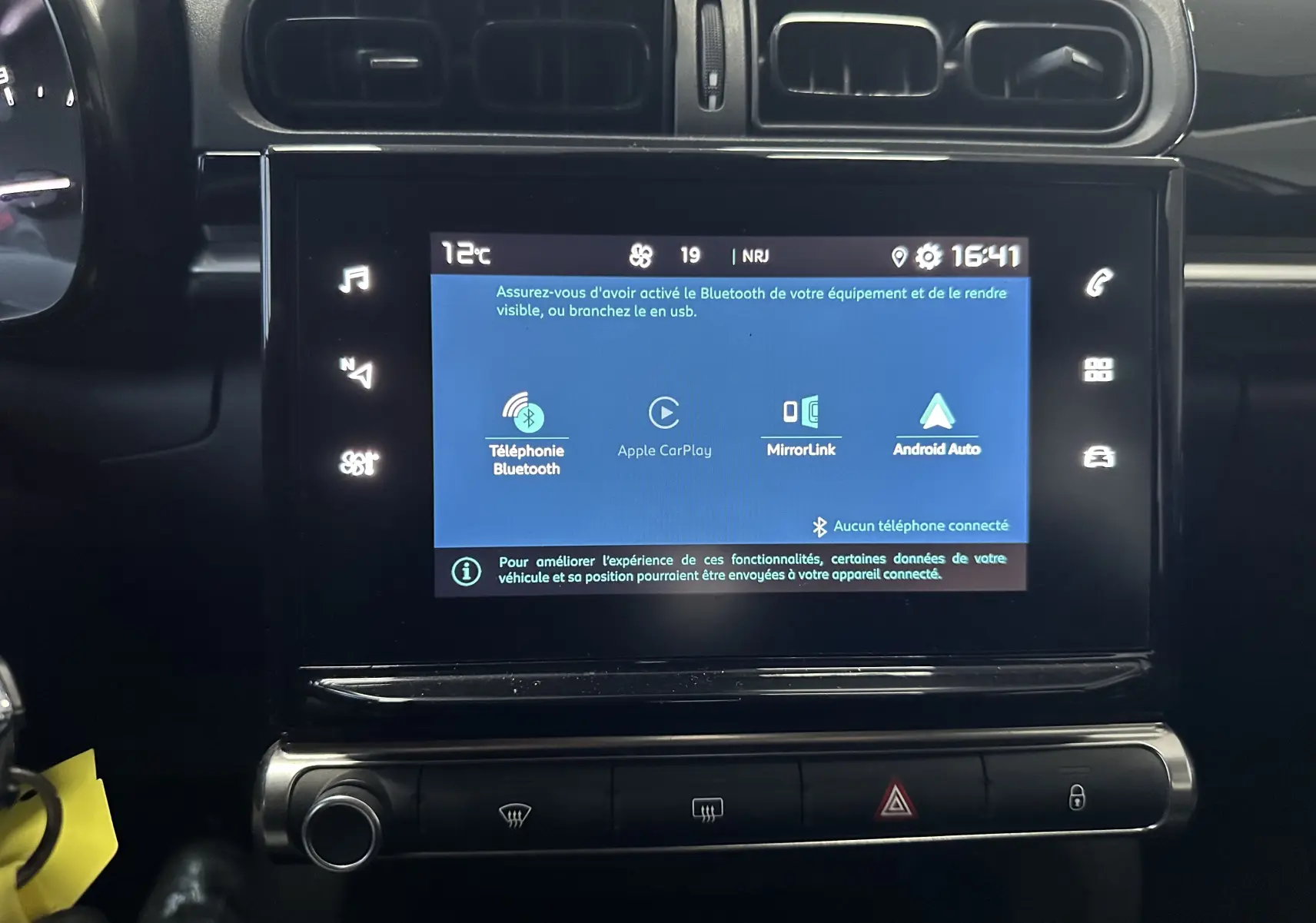 Vue rapprochée de l’écran tactile central noir de la Citroën C3 blanche, affichant les options Bluetooth, Apple CarPlay et Android Auto.