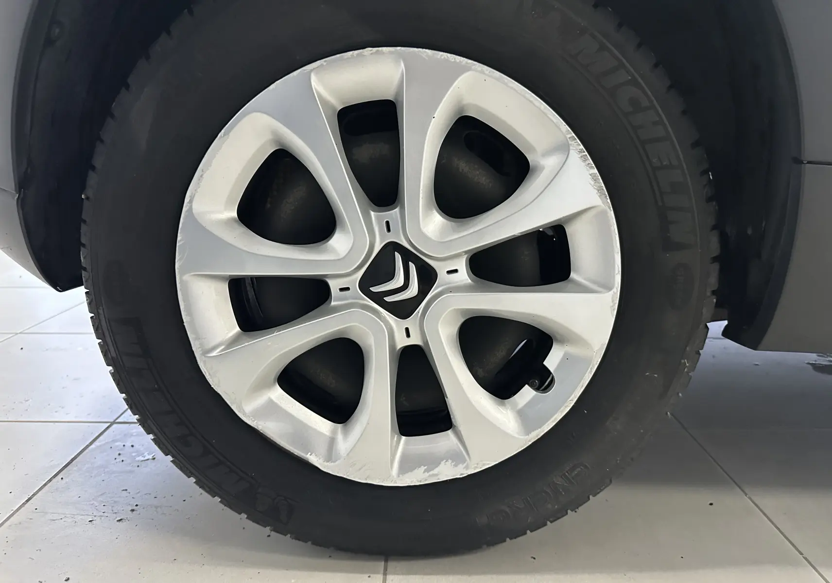 Gros plan sur la jante en alliage argentée avec logo Citroën, montée sur un pneu Michelin noir.