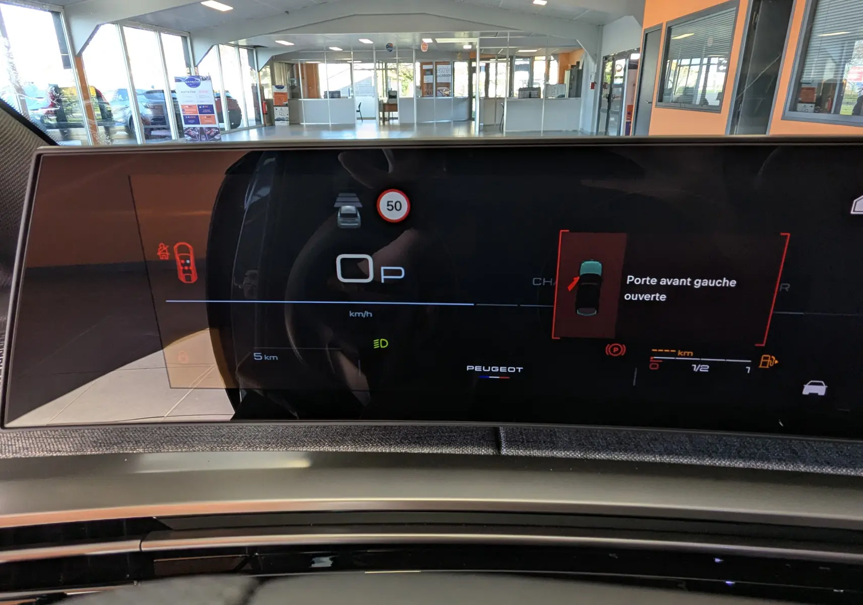 Affichage numérique du tableau de bord du Peugeot 3008 blanc, indiquant la porte avant gauche ouverte et la vitesse à 0 km/h.