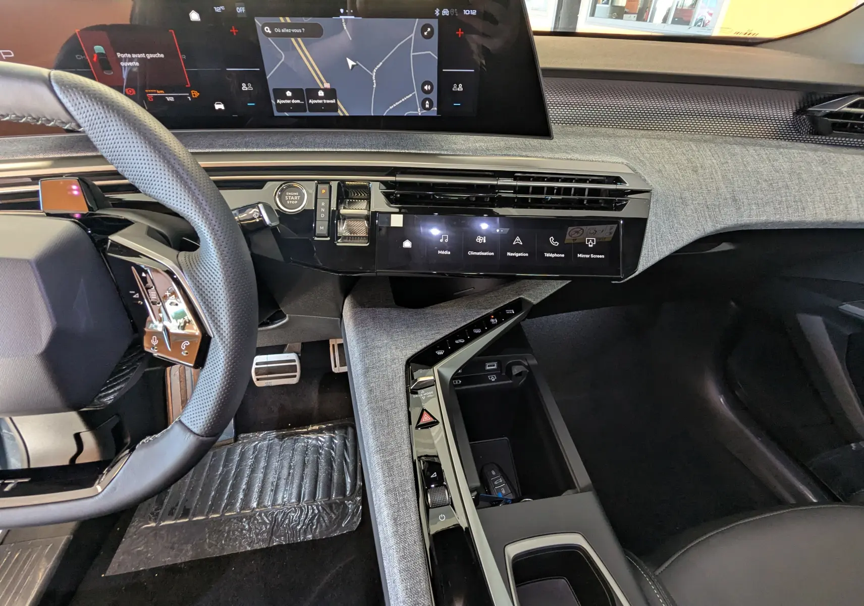 Vue intérieure côté conducteur du Peugeot 3008 Hybrid 2026, tableau de bord moderne avec écran tactile et volant multifonction.