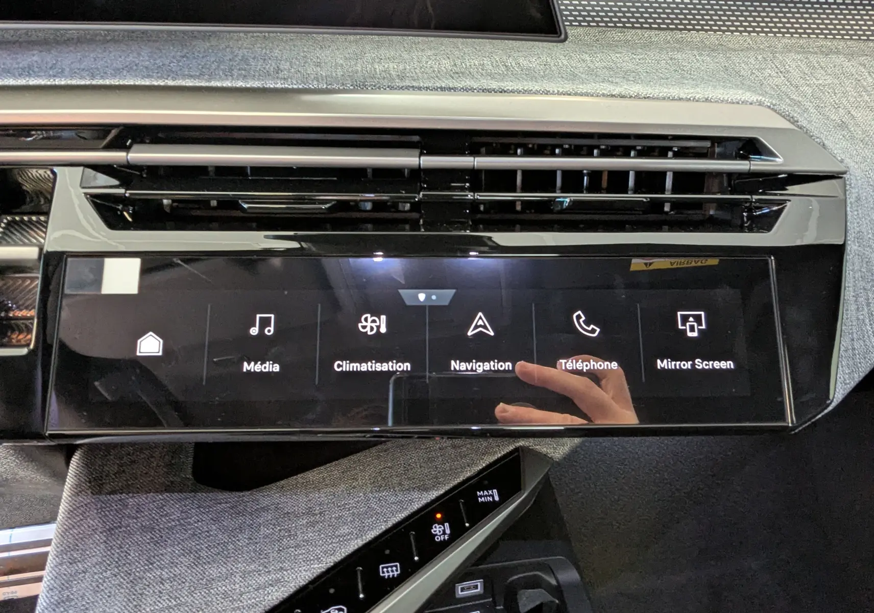 Vue rapprochée de l’écran tactile central noir du tableau de bord du Peugeot 3008 blanc Okenite, affichant les menus multimédia et navigation.