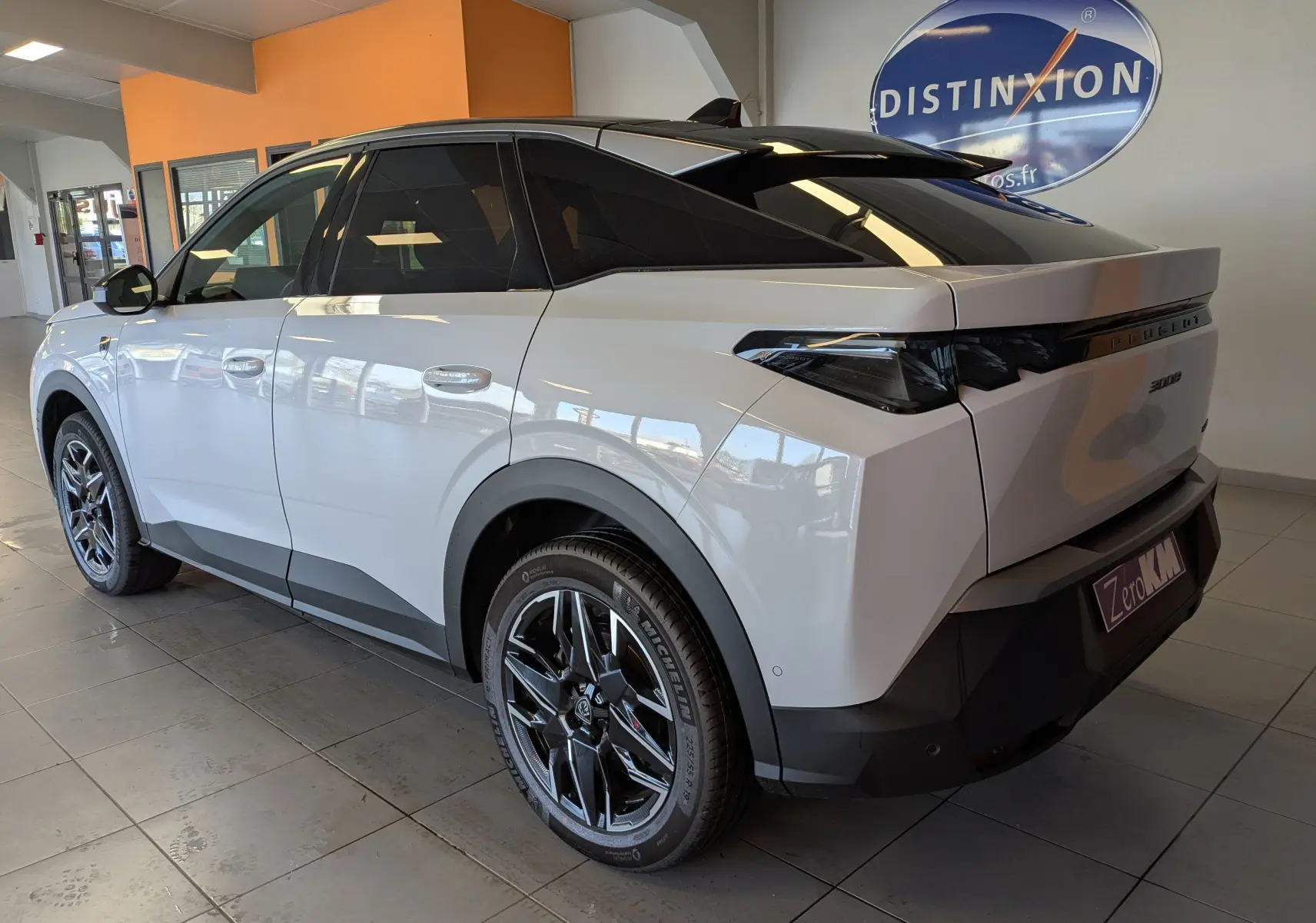 Vue 3/4 arrière droite du Peugeot 3008 blanc Okenite, soulignant ses jantes noires et son toit noir contrastant.