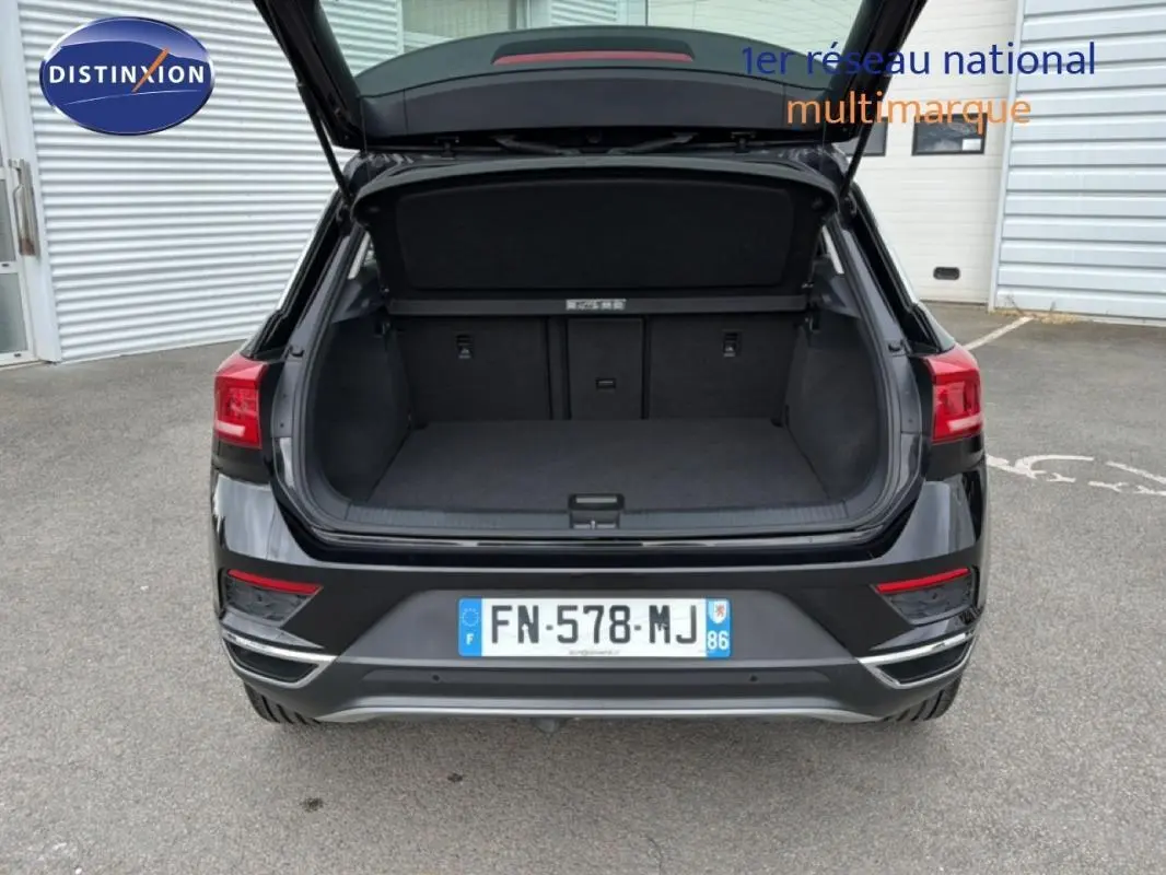 Vue arrière d’un Volkswagen T-Roc noir 2020 avec coffre ouvert, montrant l’espace de chargement vide.