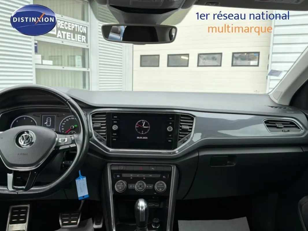 Vue intérieure du tableau de bord noir du Volkswagen T-Roc 2020 avec volant multifonctions et écran central tactile.