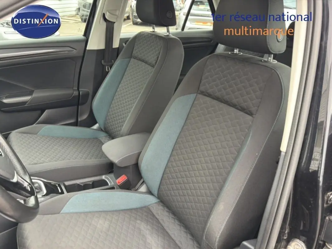 Vue intérieure côté gauche du Volkswagen T-Roc noir 2020, mettant en valeur les sièges avant en tissu gris à motifs.