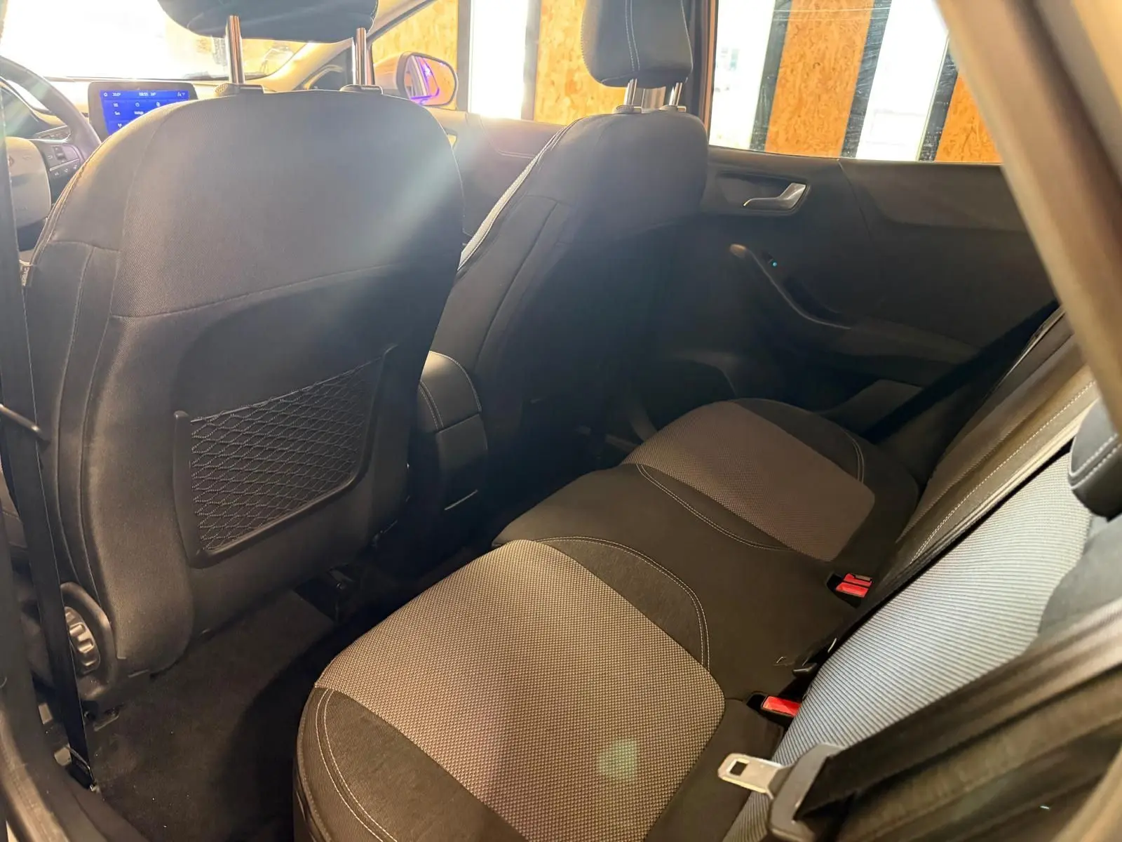 Vue intérieure arrière côté droit du Ford Puma 1.0 EcoBoost 125 MHEV Titanium avec sièges tissu noir et gris.