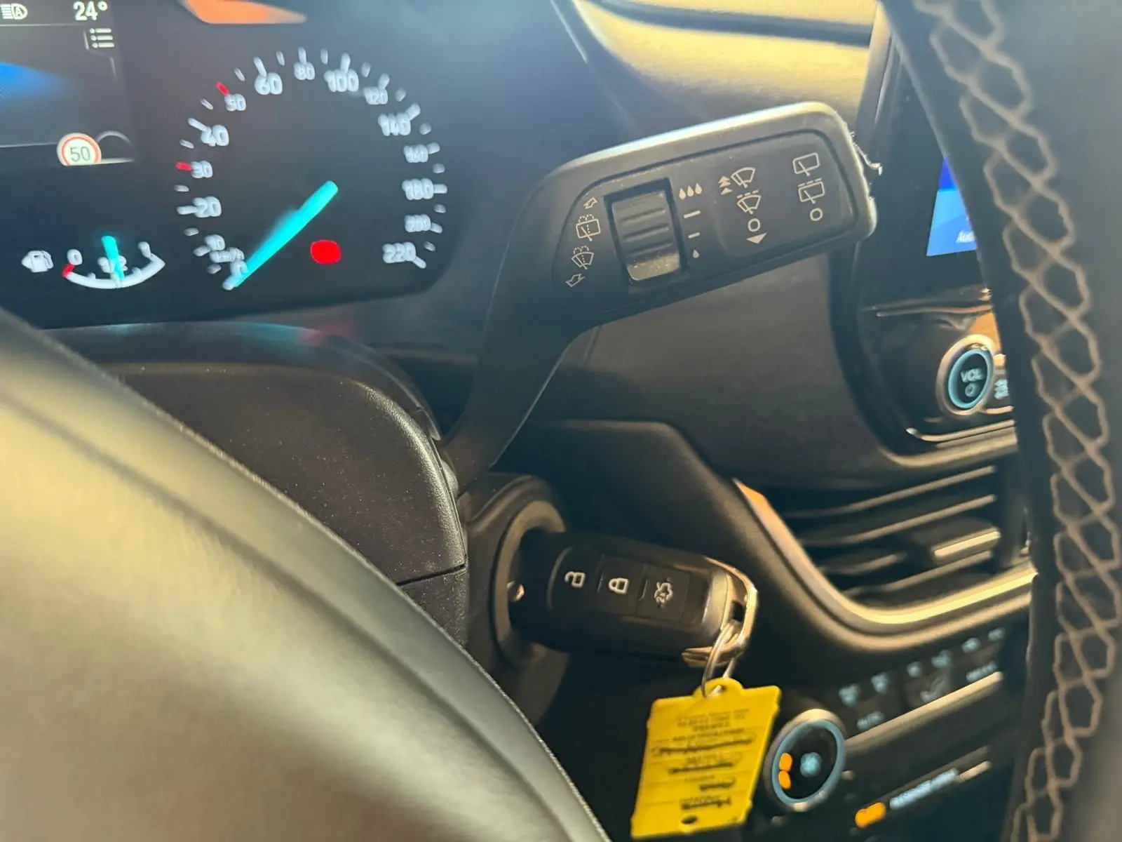 Détail intérieur du tableau de bord côté gauche d’un Ford Puma gris 2021, avec clé insérée et commandes au volant visibles.