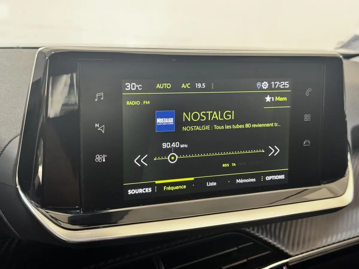 Écran tactile central du tableau de bord du Peugeot 2008 noir, affichant la radio FM sur la station Nostalgie.