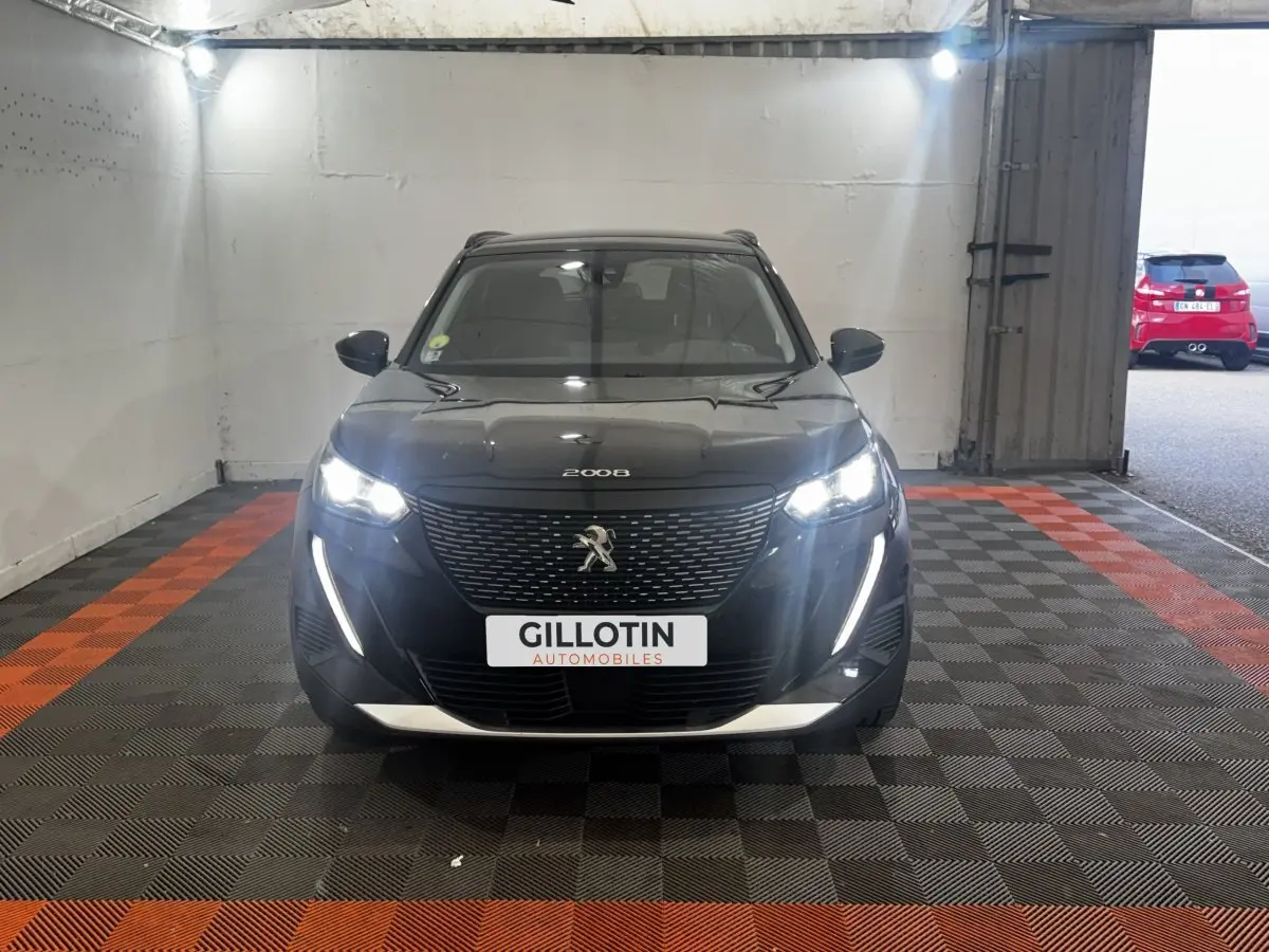 Vue avant d'un Peugeot 2008 noir avec feux LED allumés, calandre noire et plaque d'immatriculation GILLOTIN.