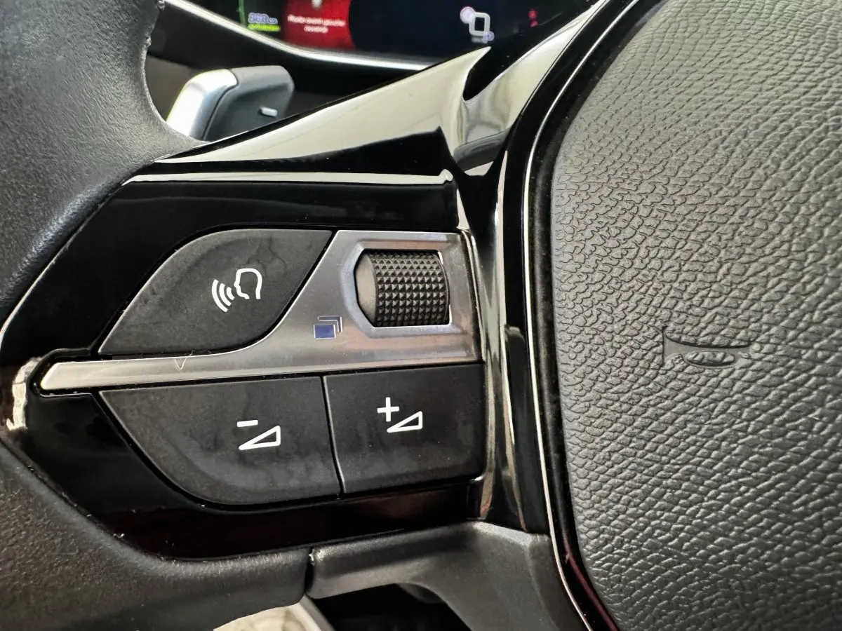 Gros plan sur les commandes vocales et volume du volant cuir noir du Peugeot 2008 BlueHDi 130 Allure Pack 2022.