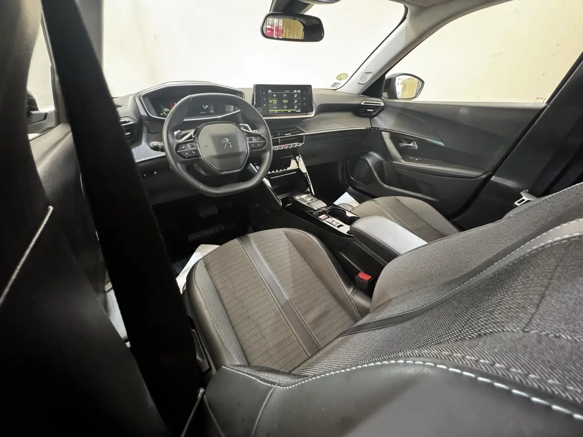 Intérieur avant droit du Peugeot 2008 noir 2022, volant cuir multifonctions et écran tactile central visible.