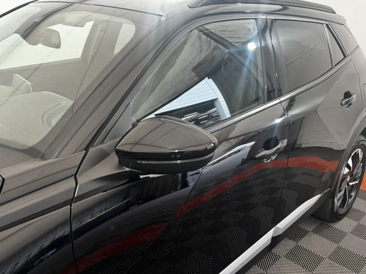 Vue latérale droite du Peugeot 2008 noir 2022 avec rétroviseur et jantes noires distinctives.