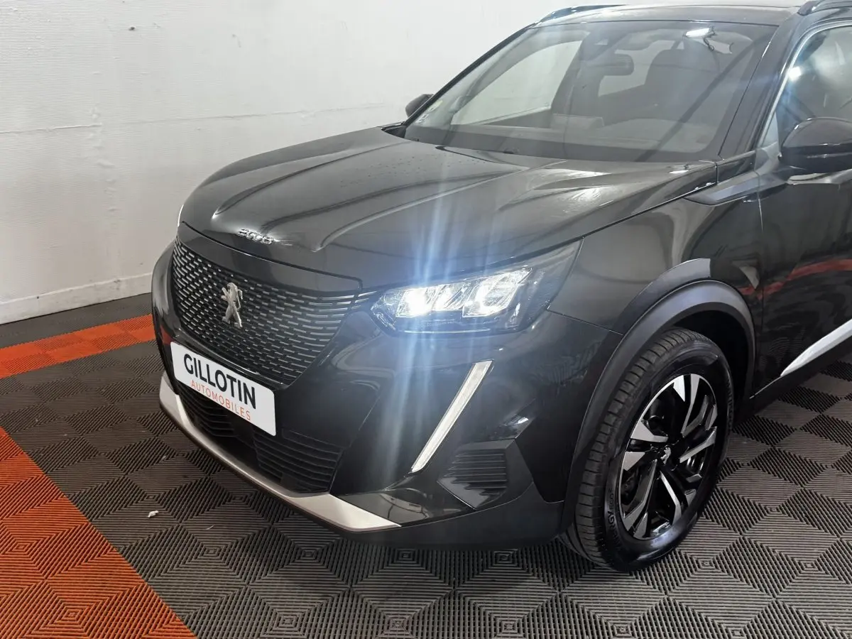 Peugeot 2008 noir vue 3/4 avant droit avec phares LED allumés et jantes alliage distinctives.