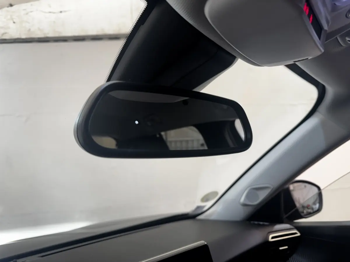 Vue intérieure du rétroviseur central et tableau de bord noir d'une Peugeot 2008 BlueHDi 130 de 2022.