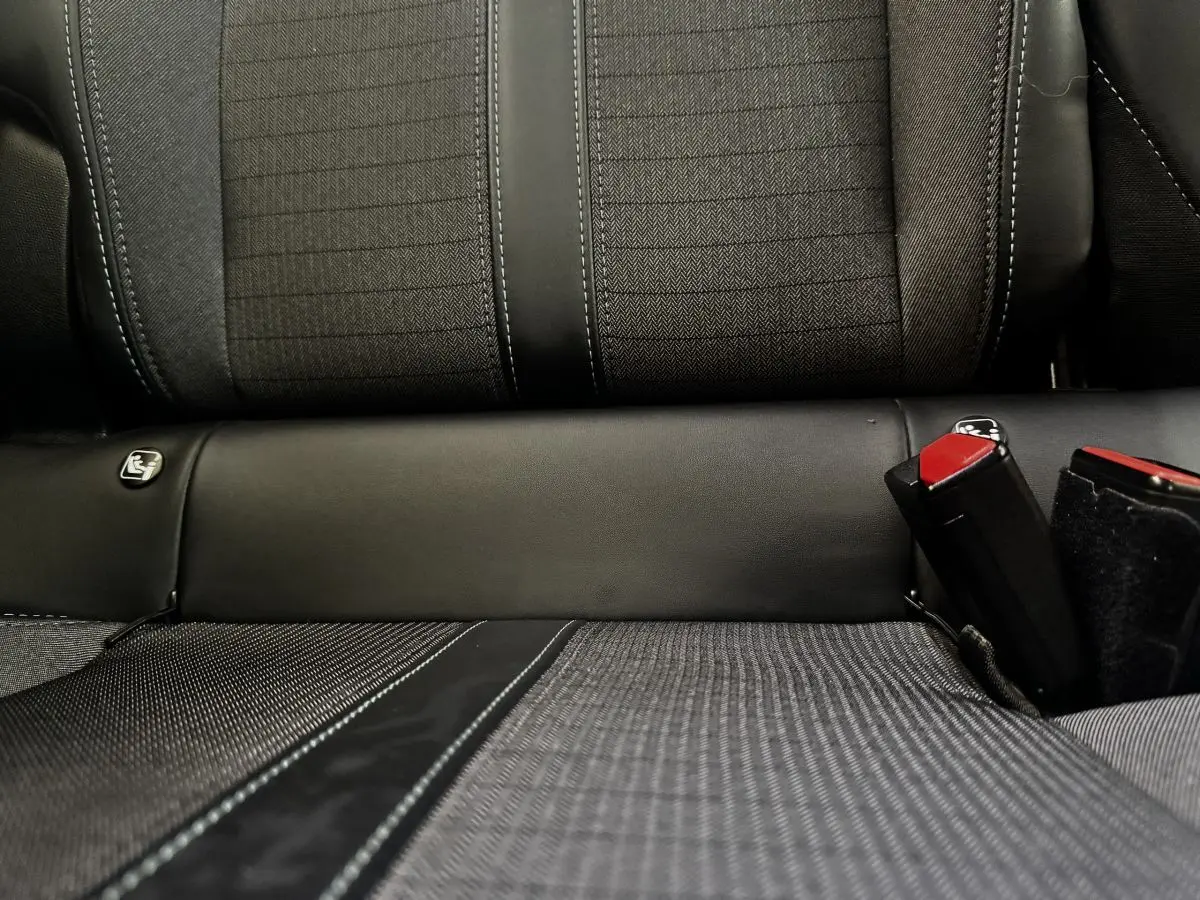 Gros plan sur la banquette arrière noire du Peugeot 2008, avec ceinture de sécurité rouge visible à droite.