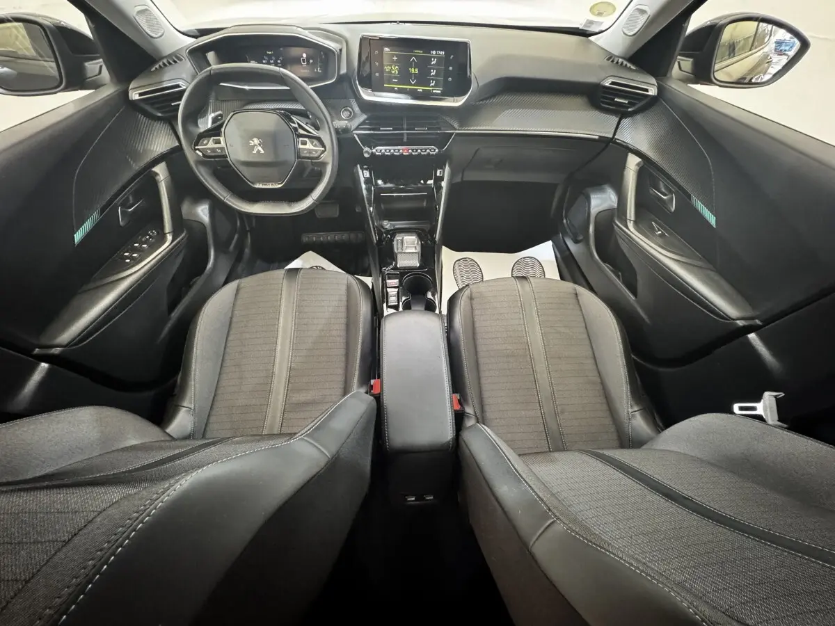 Vue intérieure avant du Peugeot 2008 noir 2022, montrant le volant cuir multifonctions et l’écran tactile central.