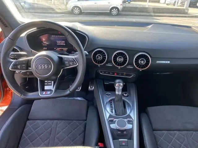 Intérieur avant de l'Audi TT orange 2021, tableau de bord avec aérateurs ronds et console centrale moderne.
