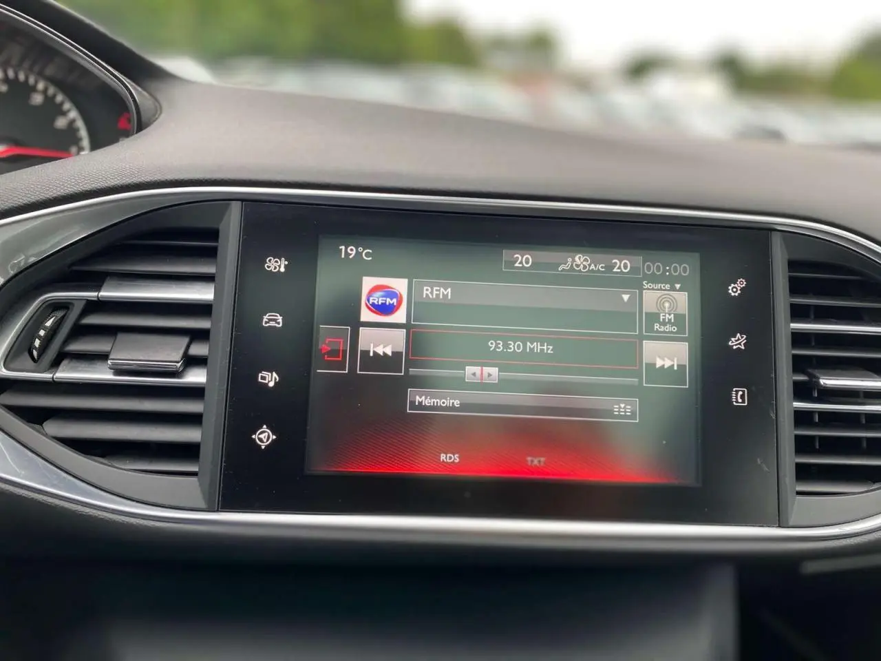 Écran tactile central de la Peugeot 308 SW 2017 affichant la radio FM avec commandes et ventilation visibles.