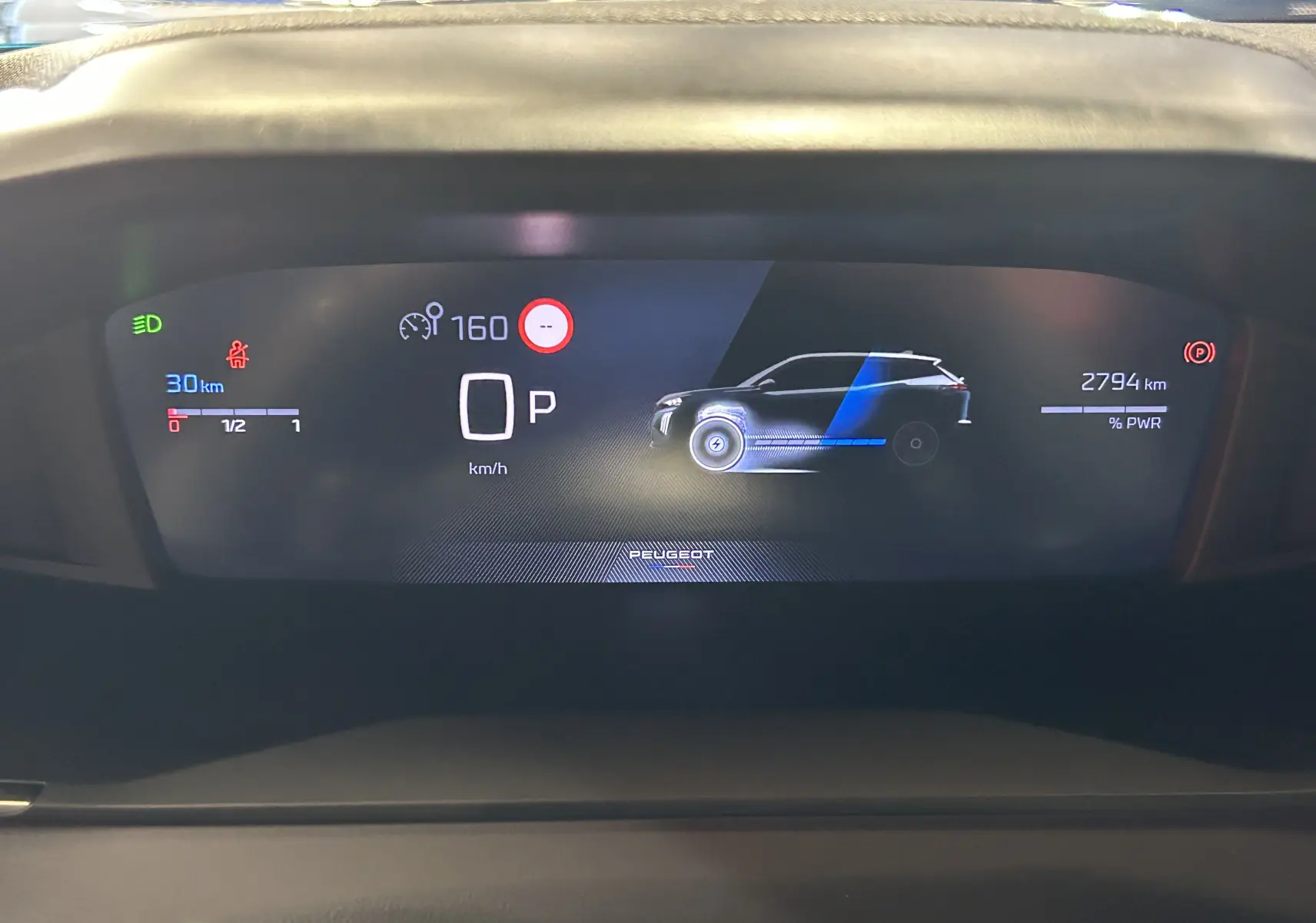 Vue du tableau de bord numérique du Peugeot 2008 Hybrid 2025, affichant la vitesse, autonomie et schéma du véhicule en mode stationnement.