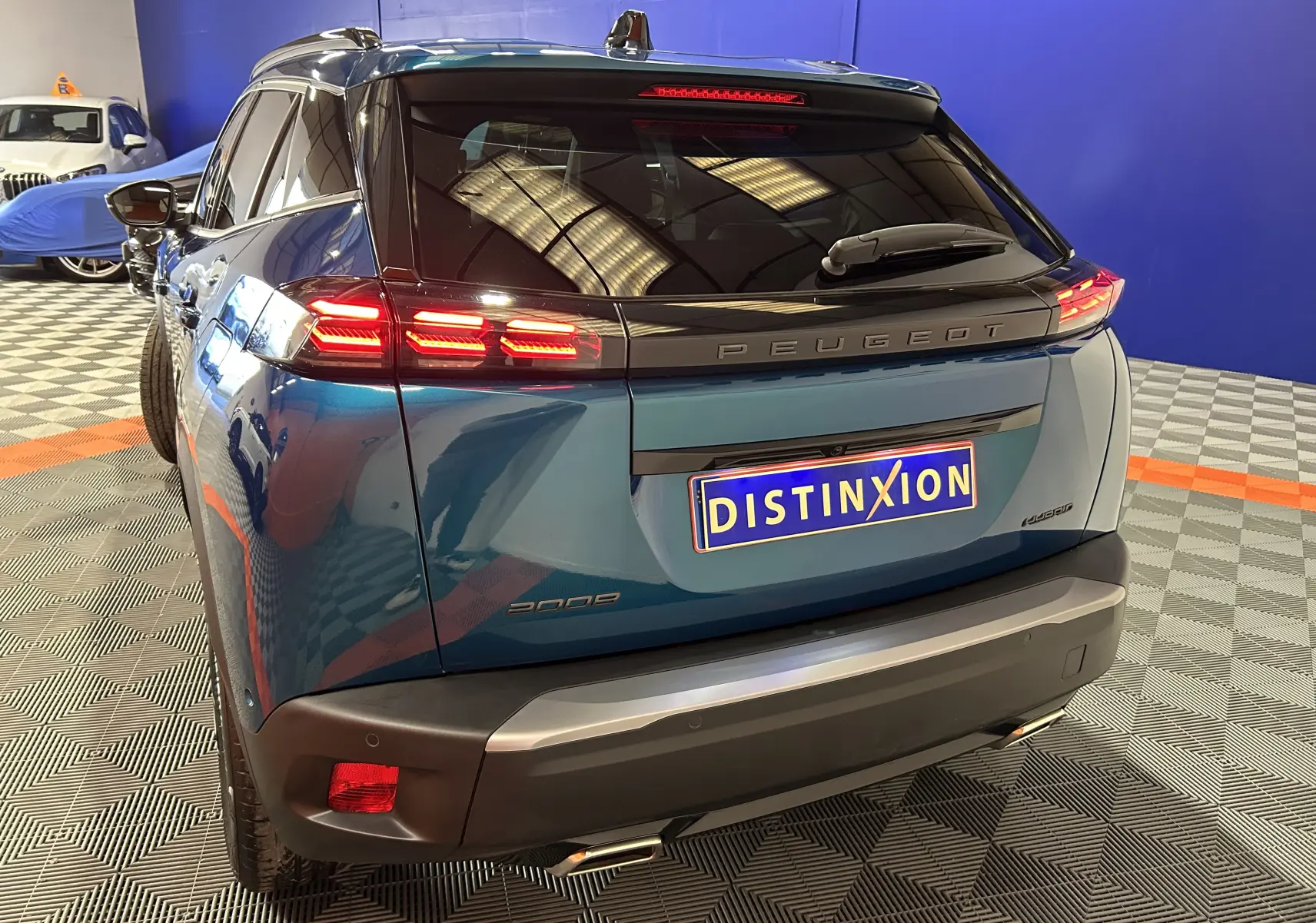 Vue 3/4 arrière droite d'un Peugeot 2008 bleu Obsession avec feux LED allumés et détails noirs brillants.