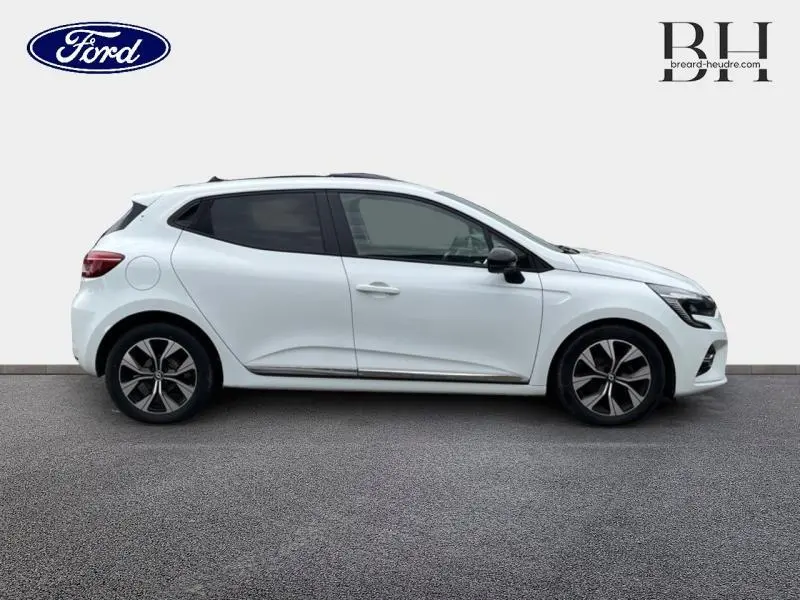 Profil droit d'une Renault Clio blanche 2022 avec jantes alliage et vitres arrière teintées.