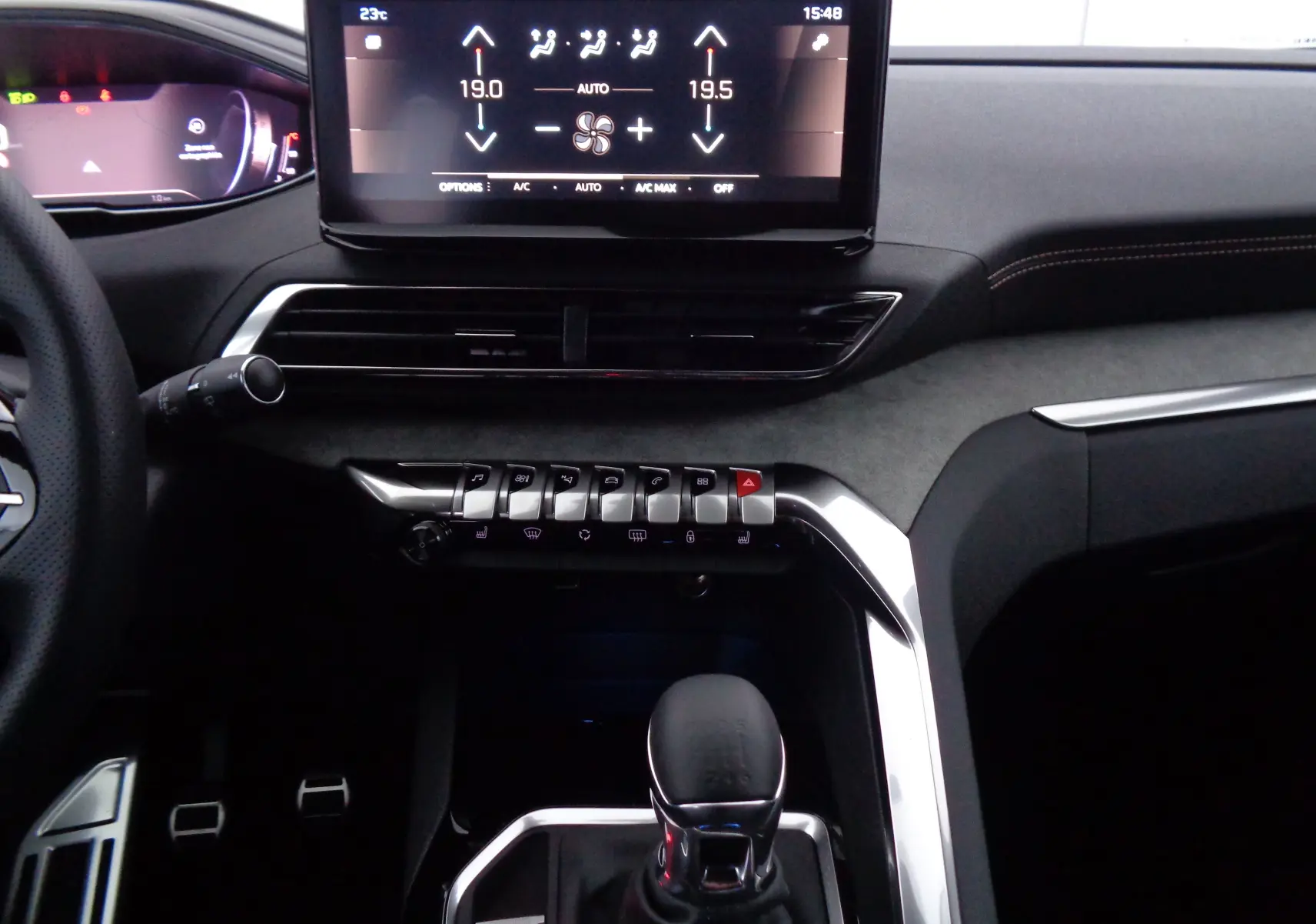 Vue rapprochée du tableau de bord et levier de vitesse manuel du Peugeot 5008 gris platinium, avec écran tactile et commandes piano.