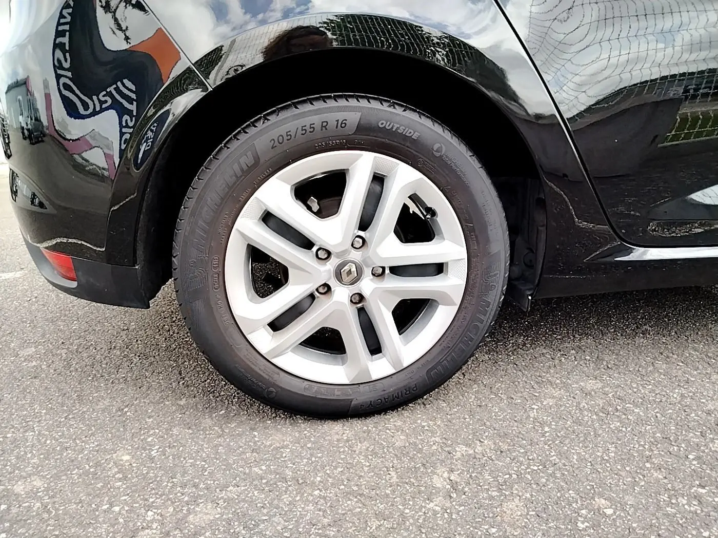 Gros plan sur la roue arrière droite noire d'une Renault Mégane IV Business TCe 140 EDC 2020 avec jante argentée.