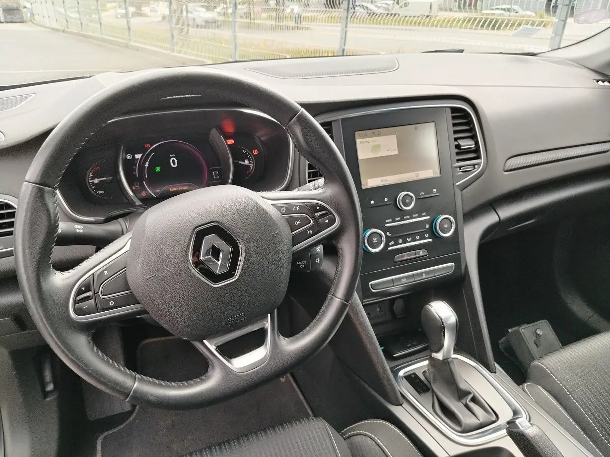 Vue intérieure du tableau de bord et volant noir de la Renault Mégane IV Business TCe 140 EDC avec écran tactile central.